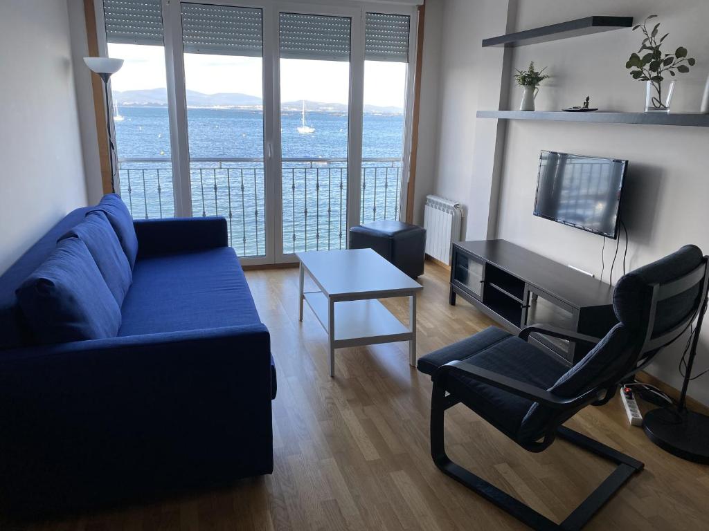 sala de estar con sofá, mesa y TV en Apartamento en la Isla con vistas al Mar, en A Illa de Arousa