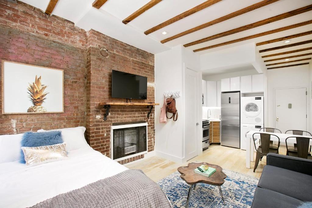 Habitación de ladrillo con cama y chimenea en 24-6 Gramercy area Newly reno Studio W D in unit en Nueva York