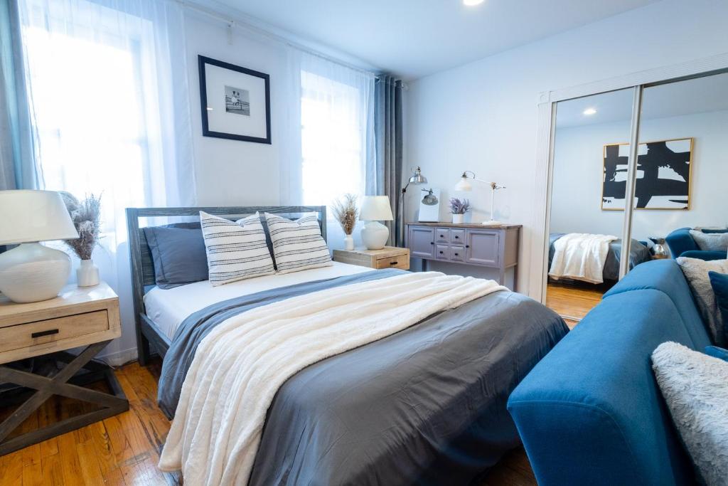1 dormitorio con 1 cama y 1 sofá azul en 350-GA Spacious Studio Gramercy Sleeps3, en Nueva York