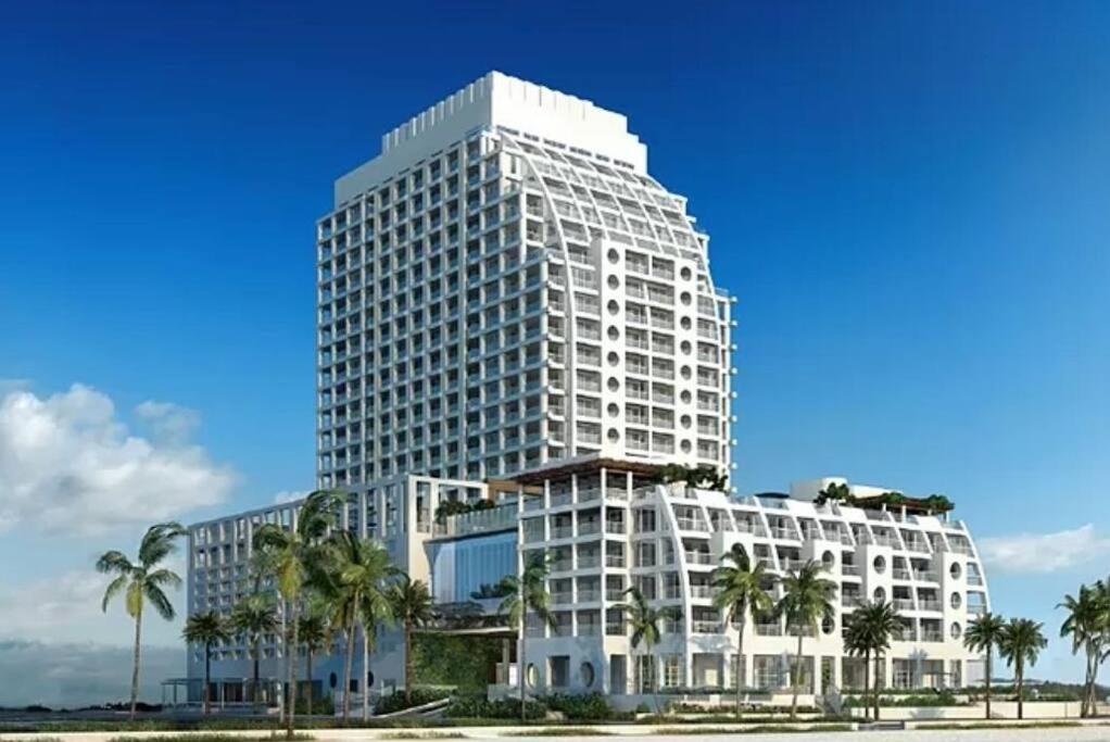 un edificio alto y blanco con palmeras delante en Cozy Condo in a Luxury Hotel!, en Fort Lauderdale