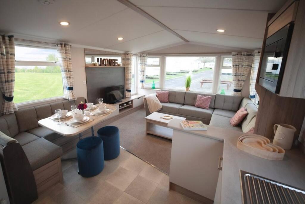 a living room with a couch and a table at Sandylands Holiday Home in Stevenston