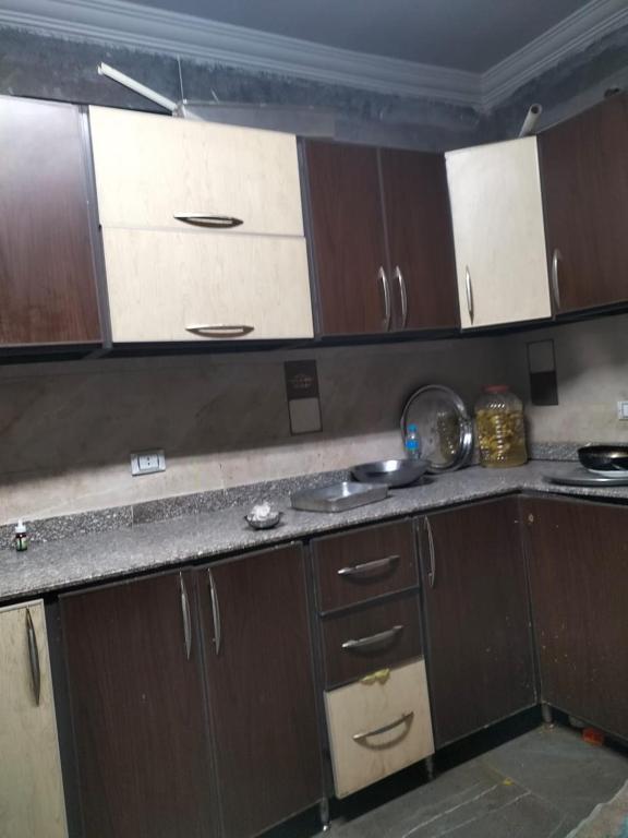 a kitchen with wooden cabinets and a counter top at شقة ايجار مفروش 4 نوم 3 حمام 4 ريسيبشن in Cairo