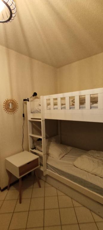a bedroom with two bunk beds and a lamp at Appart 4-6 pers au pied des pistes toutes saisons in Molines-en-Queyras