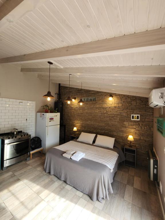a bedroom with a bed and a brick wall at La Casita in Junín de los Andes