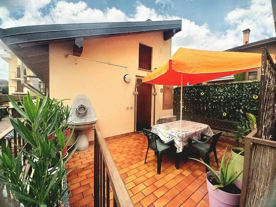 a patio with a table and an orange umbrella at Home Sweet Home in Bareggio