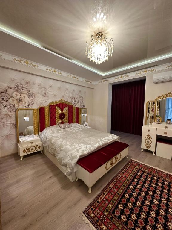 a bedroom with a large bed and a chandelier at Apartment Vefa Center in Dushanbe