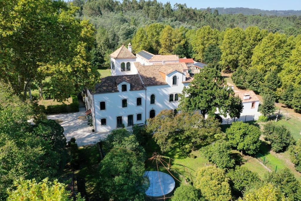 an aerial view of a large white house in the forest at Quinta do Areal in Lousã