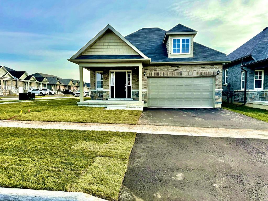 a house with a garage in a residential neighborhood at Just 5 Minuts drive from Cobourg Beach in Cobourg