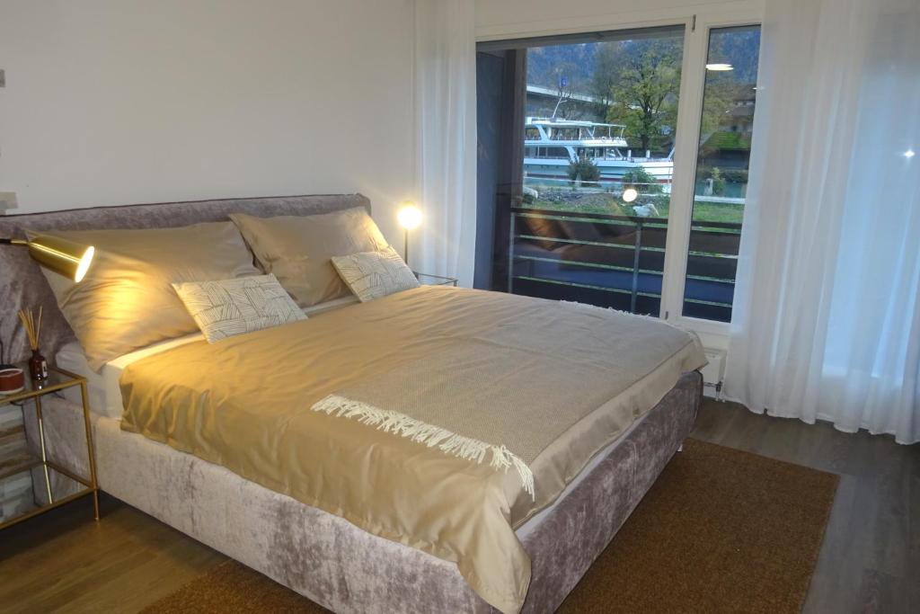 1 dormitorio con 1 cama grande y ventana grande en Aare Studio 2 en Interlaken