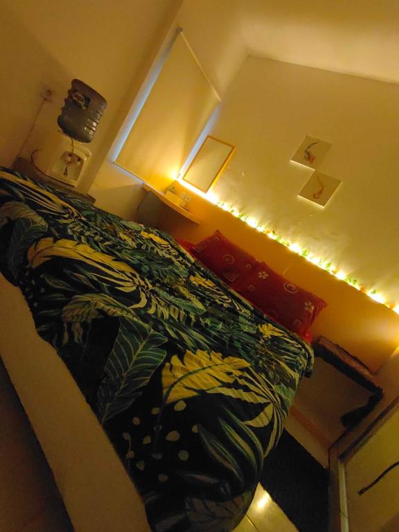 Teko的住宿－RDTROOM TRANSIT At Aeropolis，一间卧室配有一张带被子和灯的床