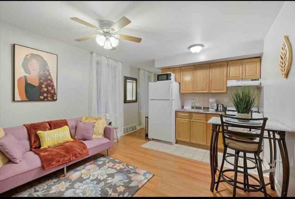 a living room with a purple couch and a kitchen at 2 Bdrm Perfectly Located In Charming Bella Vista in Philadelphia