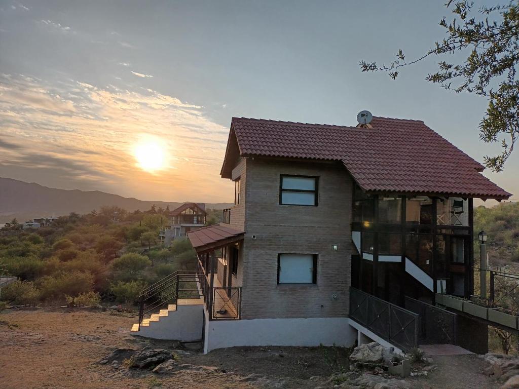 a house with the sunset in the background at Cañada Al Lago in Villa Parque Siquiman