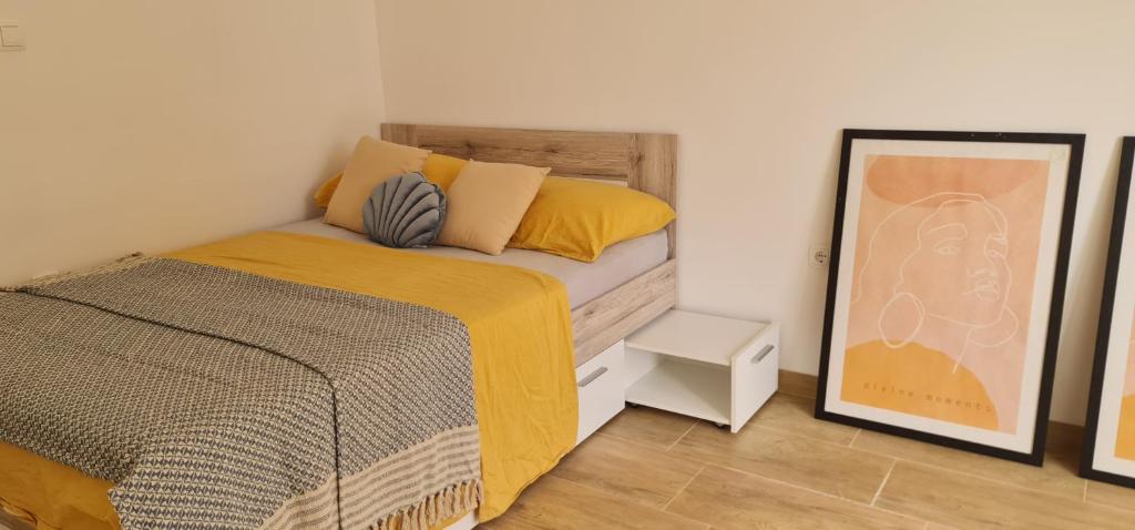 a bedroom with a bed with yellow pillows and a mirror at Trsat-Kampus apartments in Rijeka