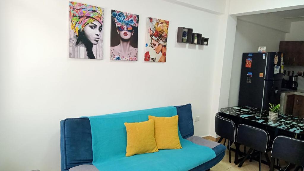 un sofá azul en una habitación con fotos en la pared en apartamento family, en Santa Rosa de Cabal