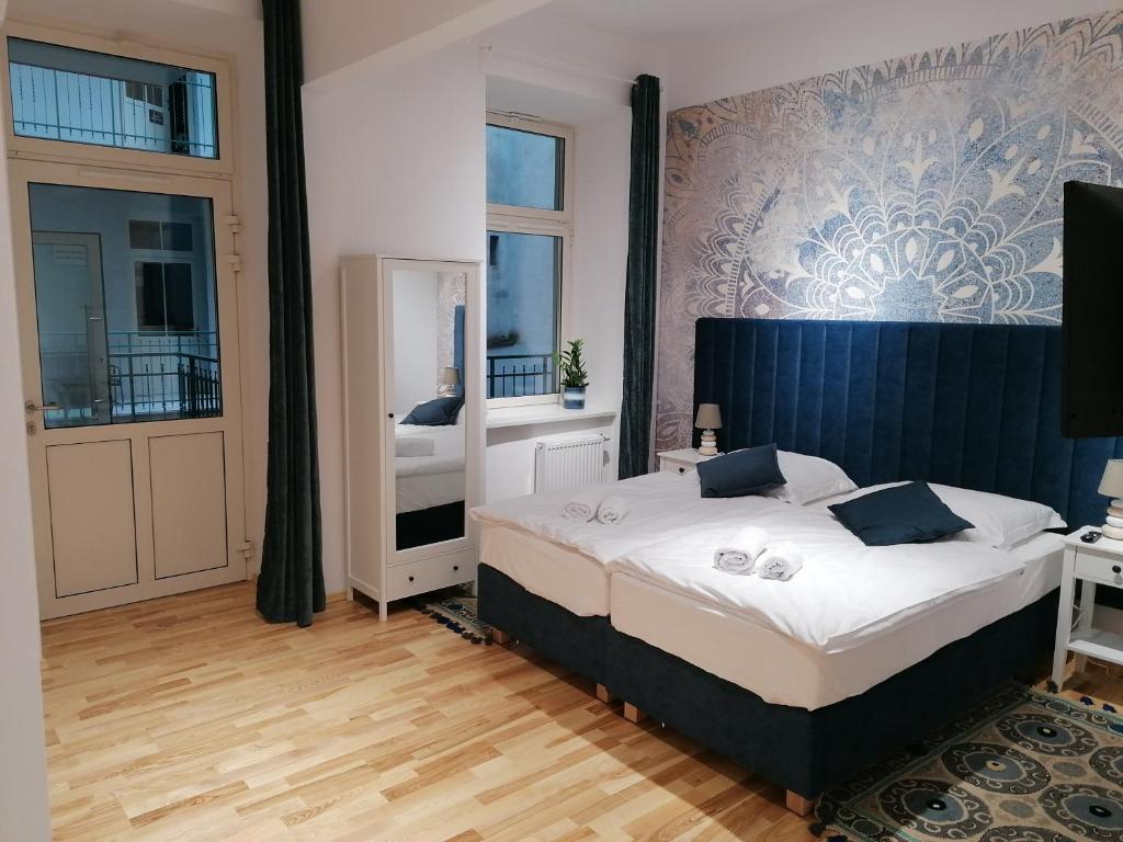 a bedroom with a large bed and a mirror at Juwel Apartments Kraków 14 in Kraków