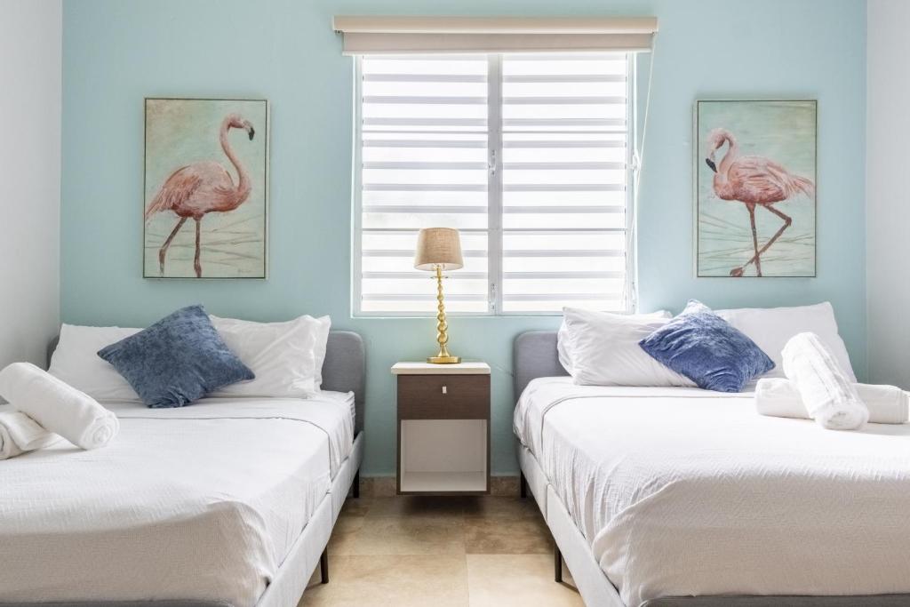 2 Betten in einem Zimmer mit zwei Vögeln an der Wand in der Unterkunft Prime Location at Condado Beach 3br 2 ba - Apt 1 in San Juan