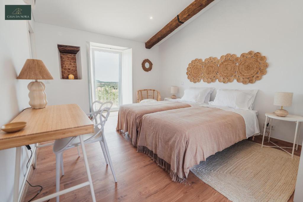 sypialnia z 2 łóżkami, stołem i biurkiem w obiekcie Casa da Nora w mieście Fortios