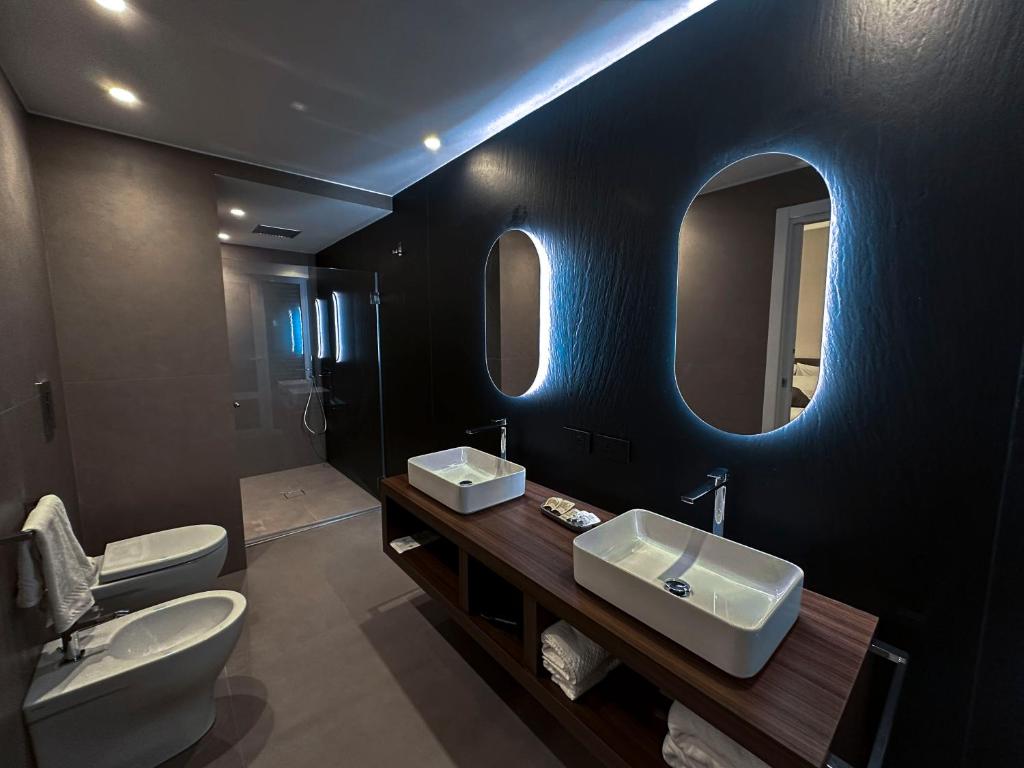 łazienka z 2 umywalkami, toaletą i lustrem w obiekcie Augusto132 w mieście Napoli