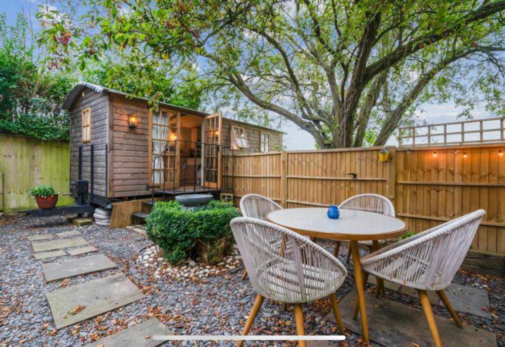 a backyard with a table and chairs and a fence at Glen Erin Hut in Gillingham