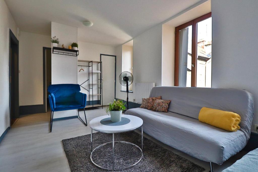 a living room with a couch and a table at Studio de 30m² hypercentre très calme in Montbéliard