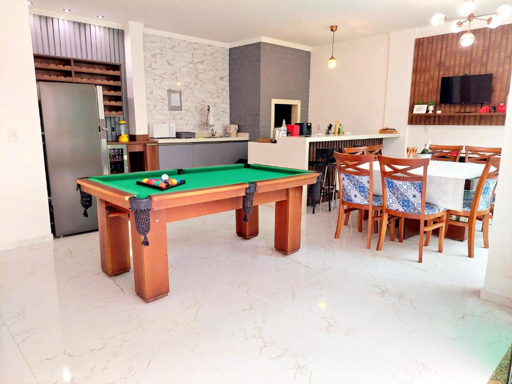 a kitchen with a pool table in a room at Aconchego Sol e Mar in Navegantes