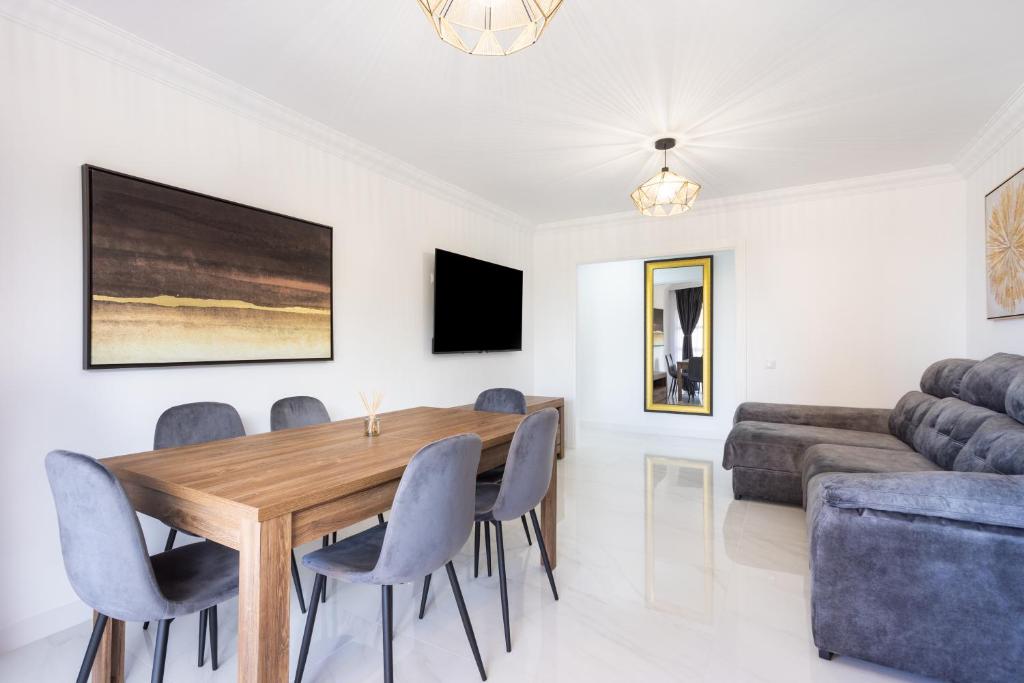 a dining room with a table and chairs and a couch at Apartamento Clara in Los Cristianos