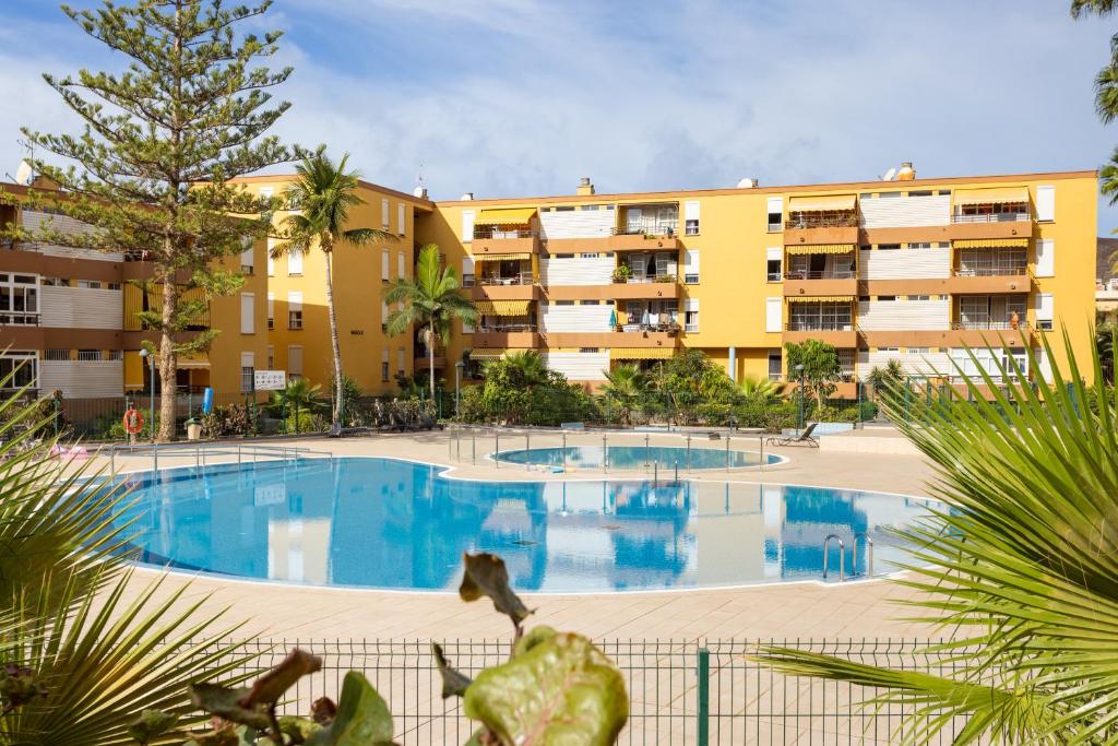 a large swimming pool in front of a building at Apartamento Clara in Los Cristianos