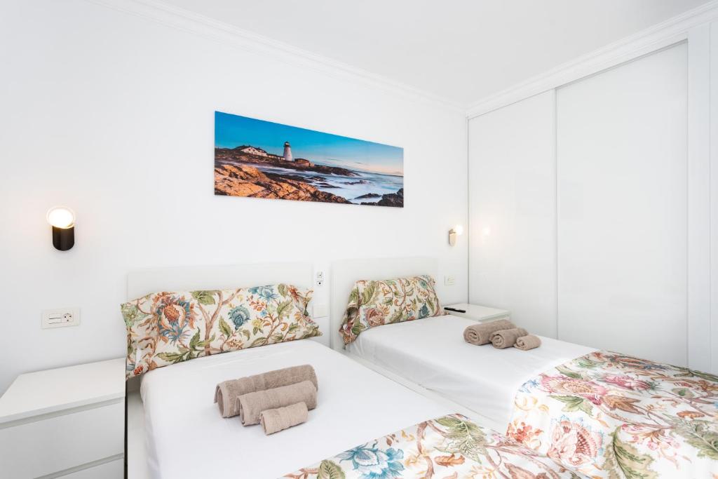 two beds in a room with white walls at Apartamento Clara in Los Cristianos