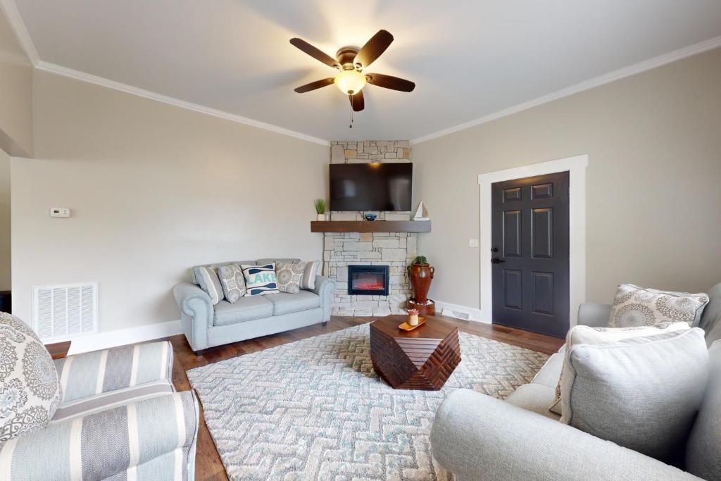 a living room with a ceiling fan and a fireplace at Norris Villa 2 in La Follette