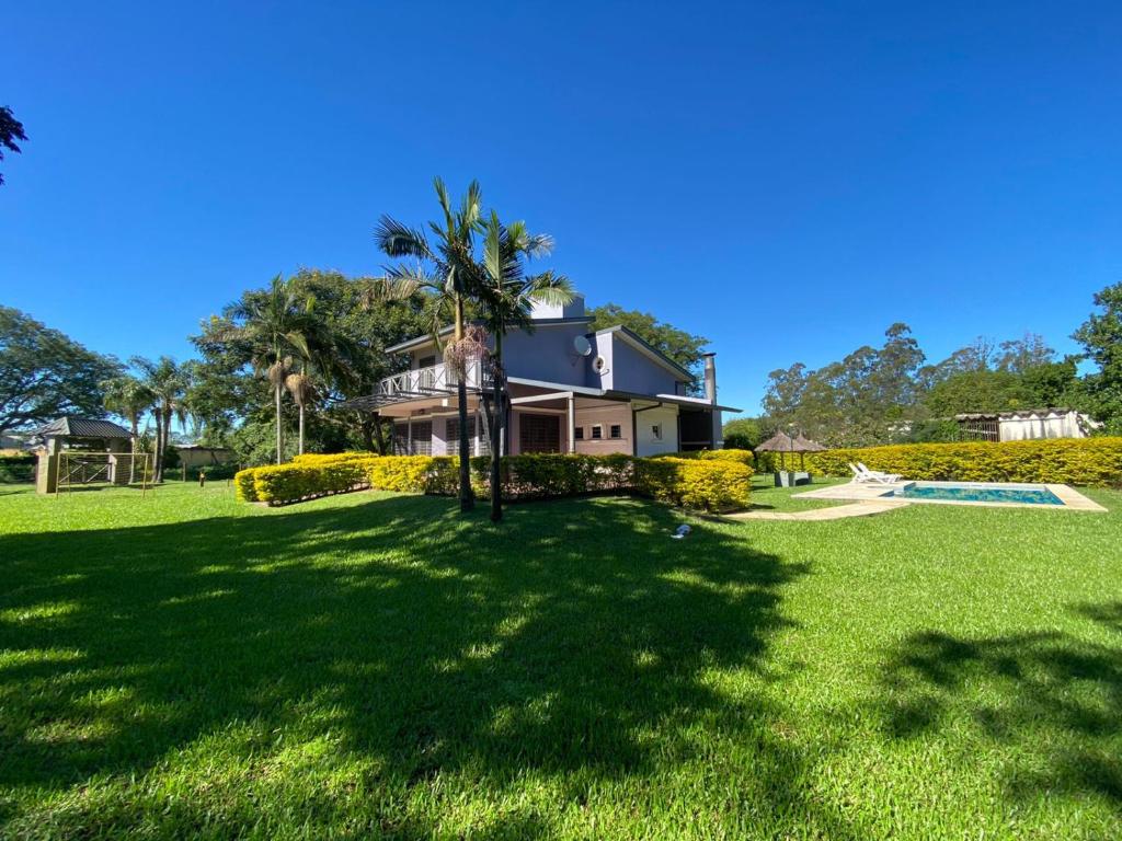a house with a palm tree in a yard at La Pocilga in Paso de la Patria