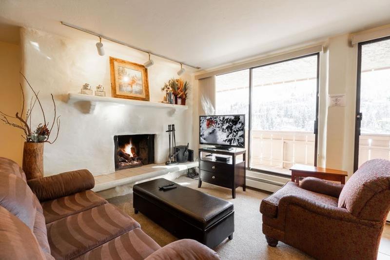 a living room with a couch and a fireplace at Condos with Ski Locker and Vail Mountain Views in Vail