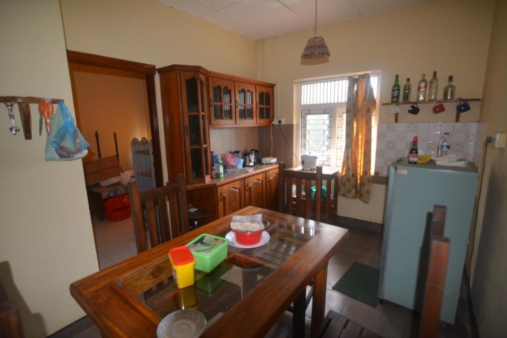 a kitchen with a table and a refrigerator at Browns Peak in Matara