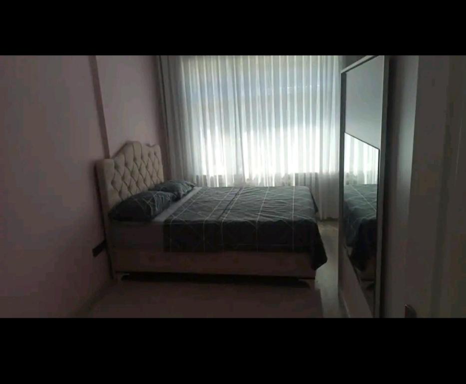 1 dormitorio con cama y ventana grande en Stylish Apartment en Estambul