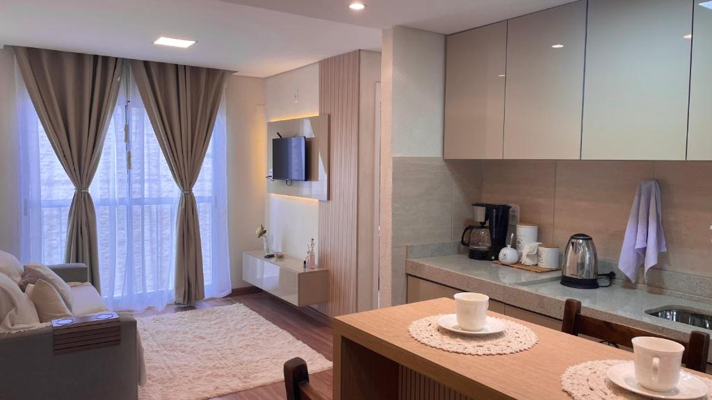 Elegante Apartamento, com ótima localização, na principal avenida de entrada em Bagé في باخي: مطبخ مع طاولة ومطبخ صغير