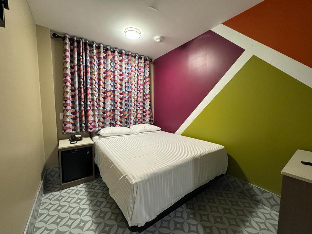 a bedroom with a bed and a colorful wall at Moon Hotel Brooklyn in Brooklyn