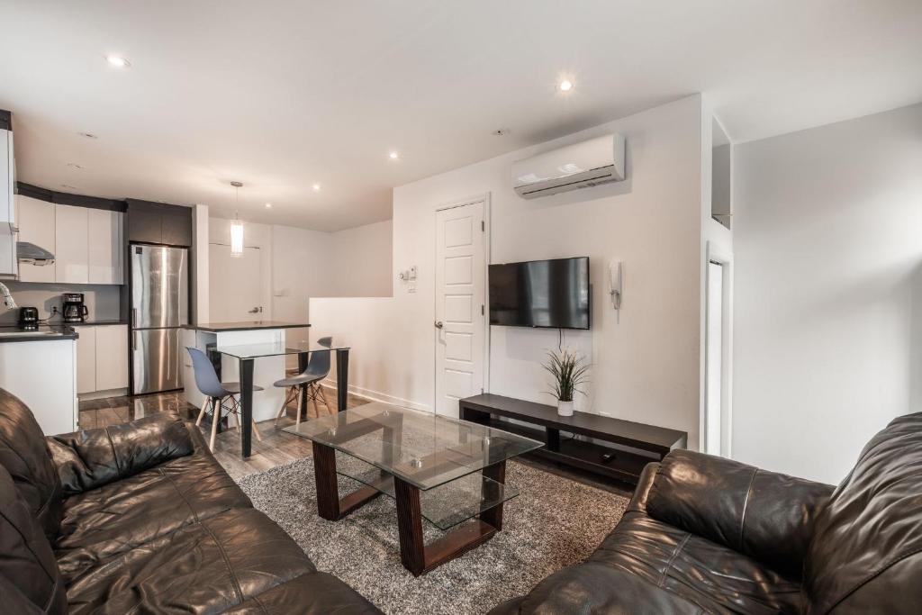 een woonkamer met een bank en een tafel bij Two bedrooms in 2 floors apartment - 101 in Montreal