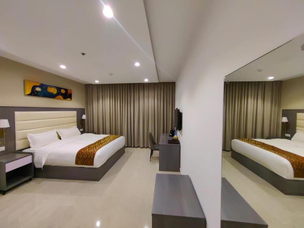 a hotel room with two beds and a television at Wave View Hotel in Seeb