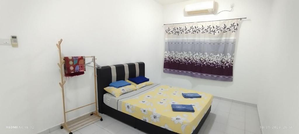 a bedroom with a bed in a white room at Nizmar Inn 2 Guesthouse & Homestay in Gambang