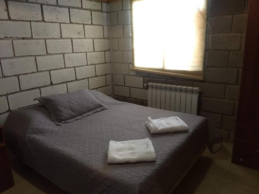 une chambre avec un lit avec deux serviettes dessus dans l'établissement Los Duraznillos, à Los Antiguos