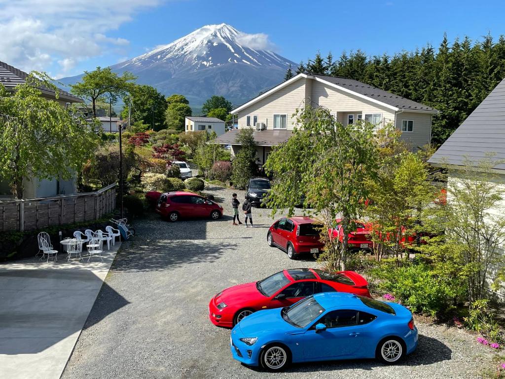 dois carros estacionados num parque de estacionamento com uma montanha ao fundo em Fujimien em Fujikawaguchiko