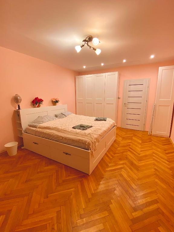 a bedroom with a bed and a wooden floor at Cheap entire apartment in a super location in Kraków