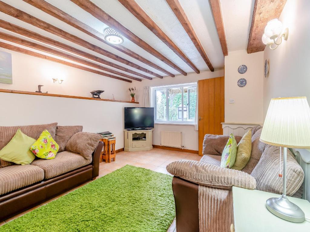 a living room with a couch and a tv at Clover Cottage- Uk45595 in Verwick