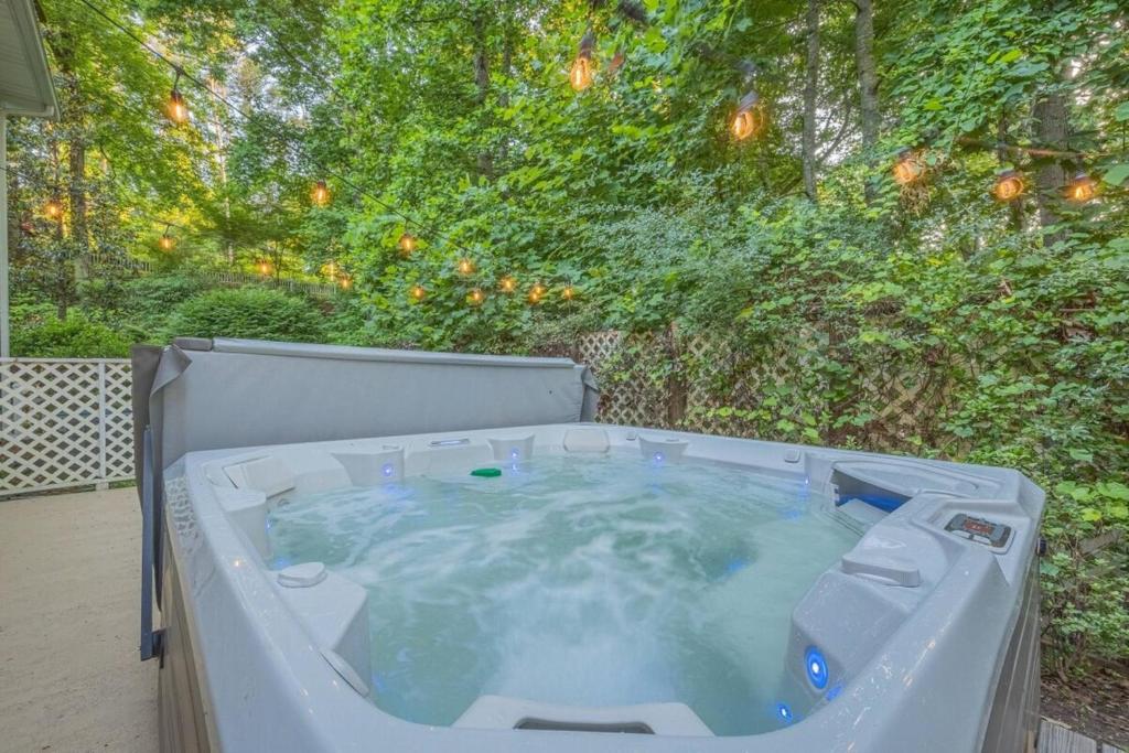 a large hot tub in a backyard with trees at Lakefront with Dock and Hot Tub! in Toccoa