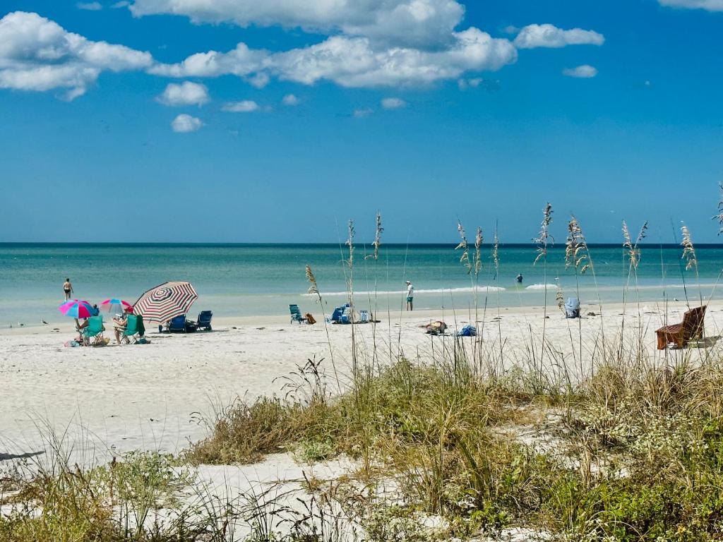 a beach with people on the sand and the ocean at Blue Water Beachside villa 2 in Clearwater Beach