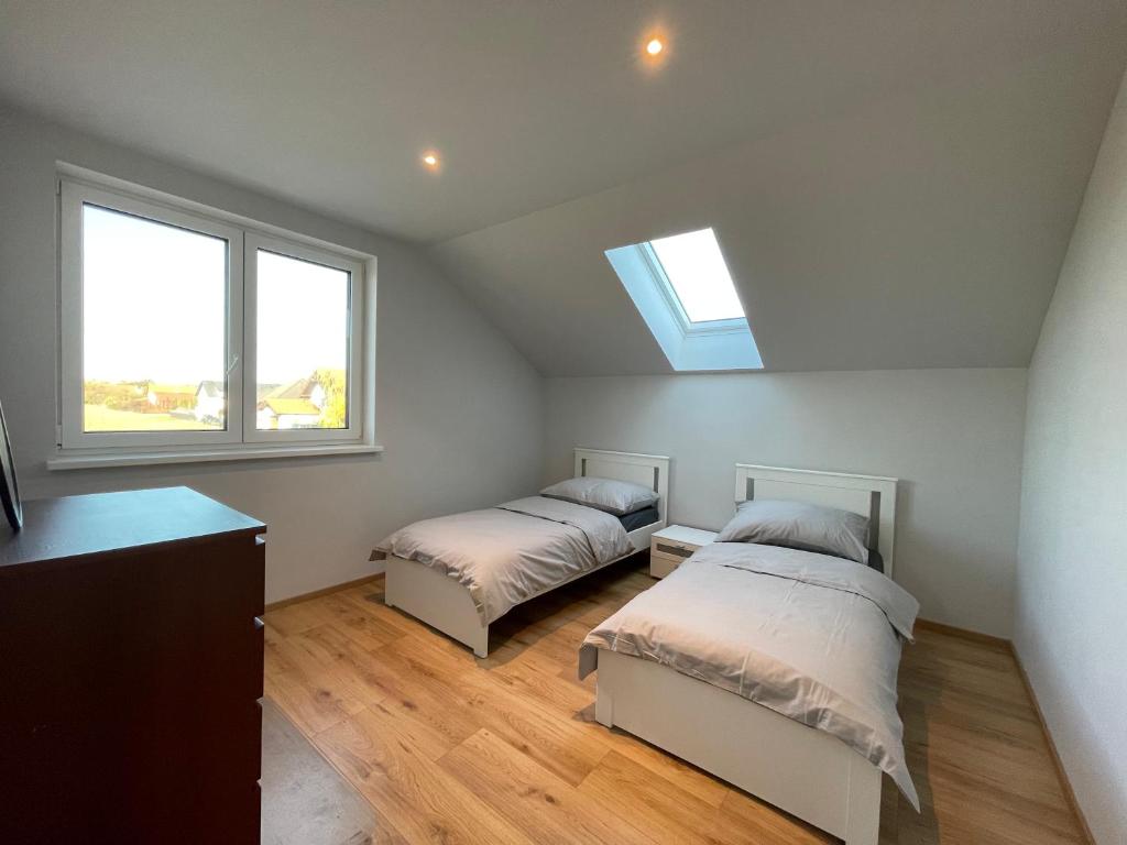 - 2 lits dans une chambre avec 2 fenêtres dans l'établissement Cozy Apartment near Vienna Airport, à Schwechat