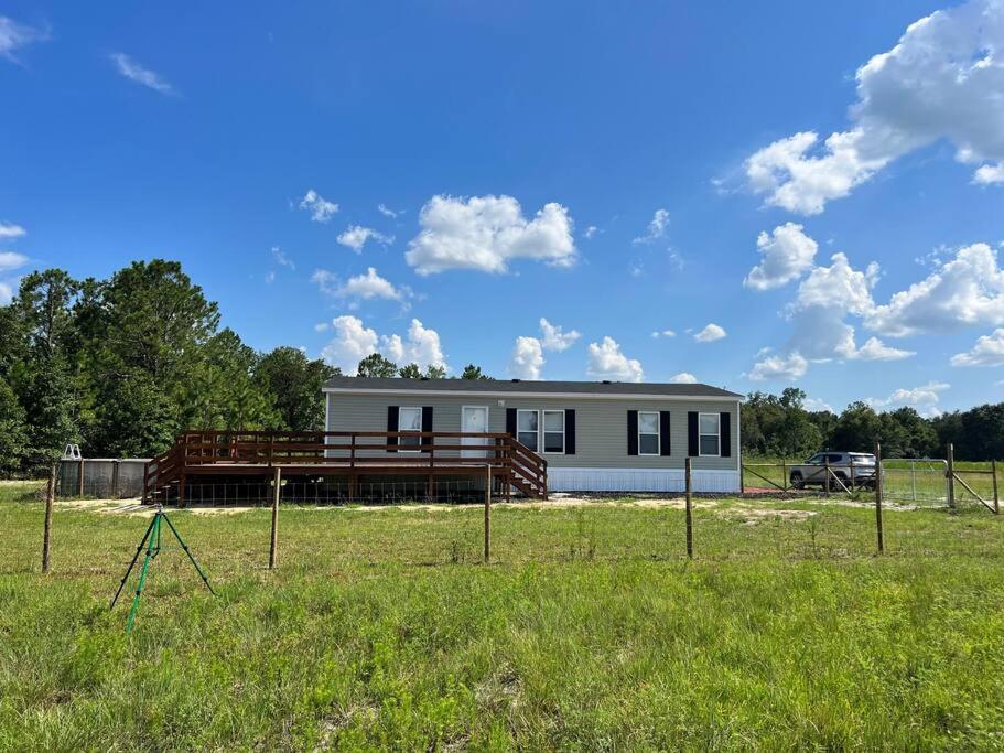 a small white house in the middle of a field at Ranch Road Retreat in Clermont