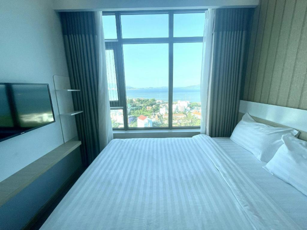 Cette chambre comprend un lit et une grande fenêtre. dans l'établissement Mường Thanh Oceanus Nha Trang, à Nha Trang