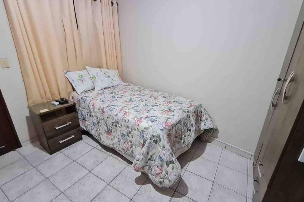 a small bedroom with a bed and a night stand at Habitación privada y céntrica /cómoda! in Santa Cruz de la Sierra