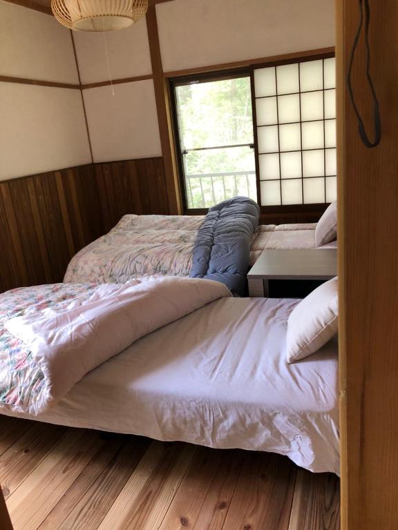 Postel nebo postele na pokoji v ubytování 陽なた山荘