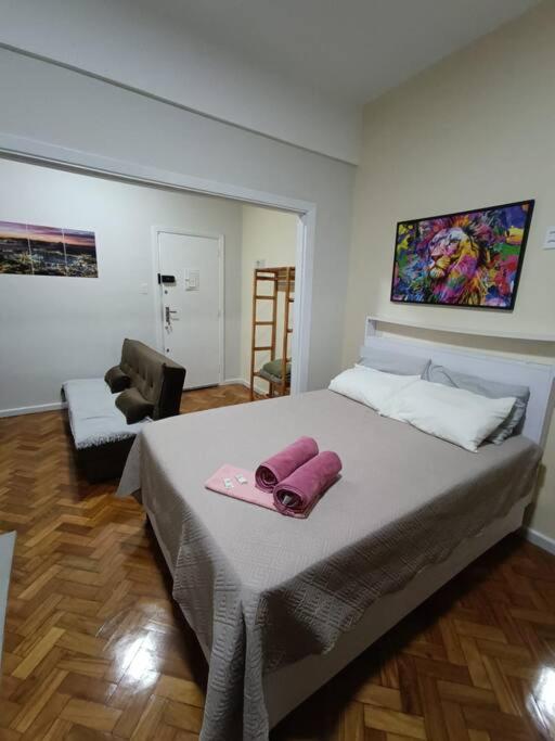 um quarto com uma cama grande e uma toalha cor-de-rosa. em Lindo Loft na Cinelândia no Rio de Janeiro